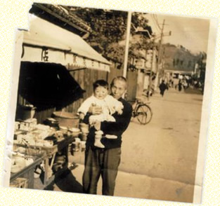 1957年に撮影。北野せともの店の前で祖父に抱っこされている時。
